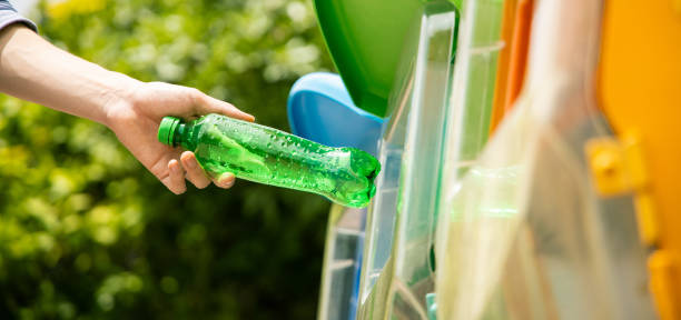 istock Man put plastic bottle into recycle bin in park. 1162564632