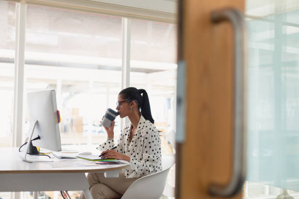 istock Female graphic designer having coffee while using graphic tablet at desk 1162565577