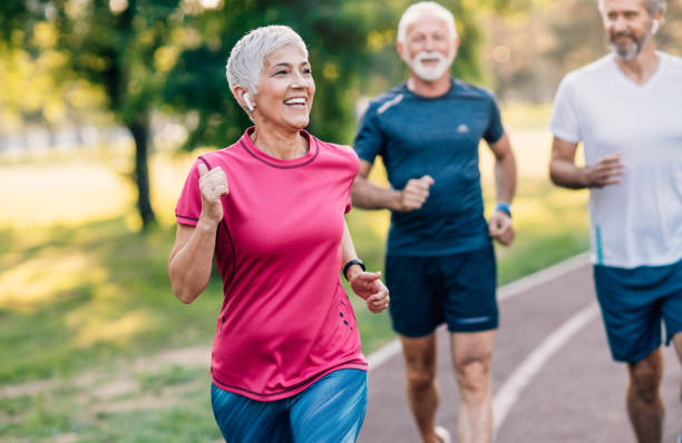 istock Smiling mature athletes jogging in the park 1162569024