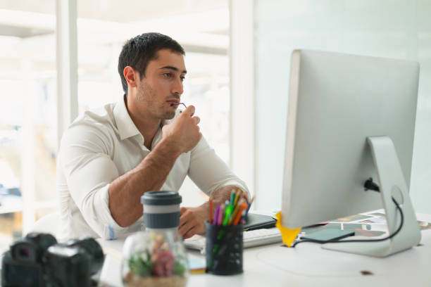 istock Male graphic designer looking at computer at desk in office 1162569082