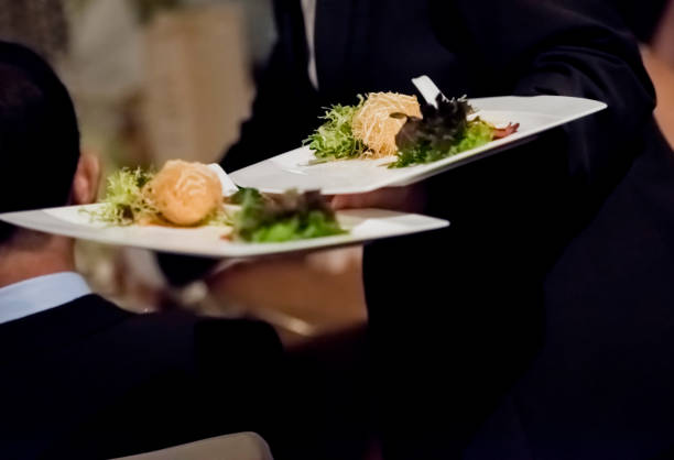 istock Two waiters serving food to the table 1162569088