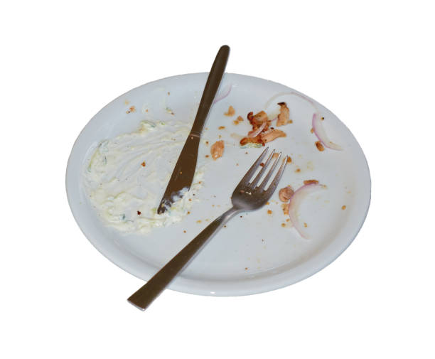 istock Empty plate with fork and knife and leftover food, isolation on white 1162569160