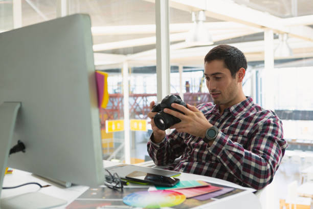 istock Male graphic designer using digital camera on desk 1162569275