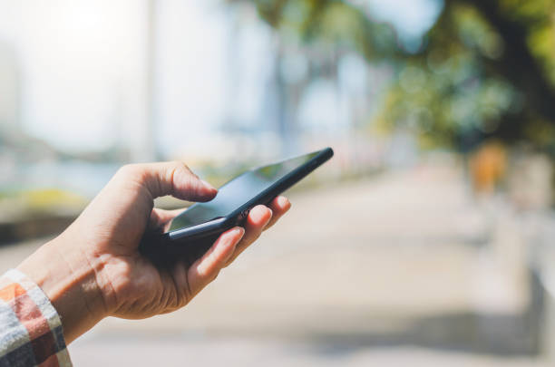 istock close up handsome man using hand typing mobile phones and touch screen working search with app devices outdoor in city with sunrise and building background. 1162570622