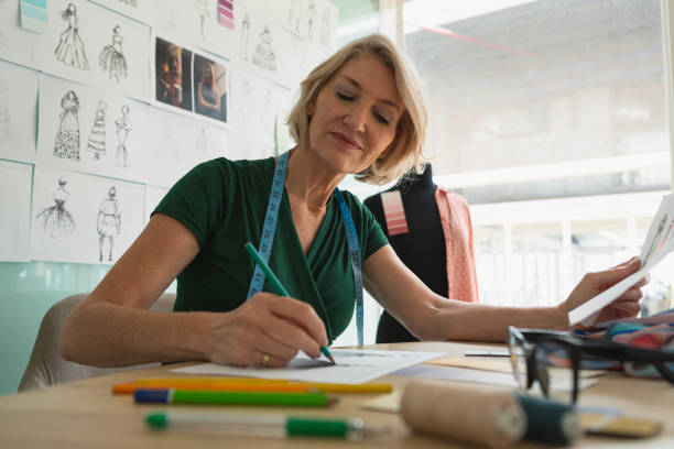 istock Female fashion designer drawing sketch on a table 1162574561