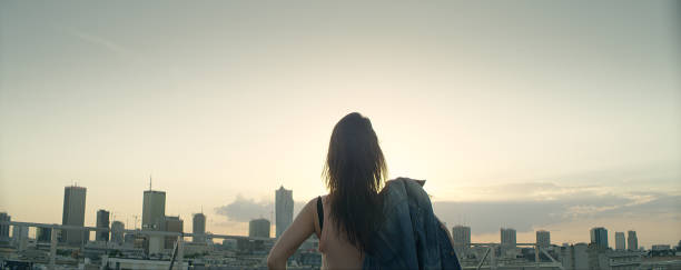 istock Young woman on a rooftop. Enjoying the sunset 1162576269