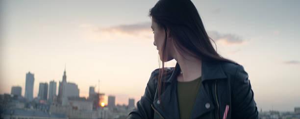 istock Young woman on a rooftop. Enjoying the sunset 1162576362