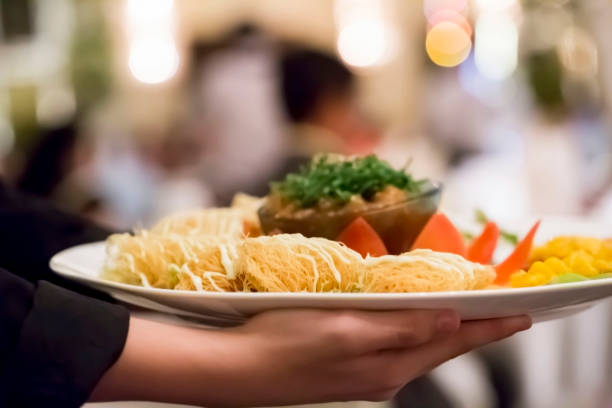 istock Waiter serving plate with food to the customers 1162577773