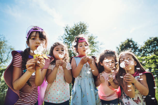 istock Happy kids blowing dandelions 1162578521