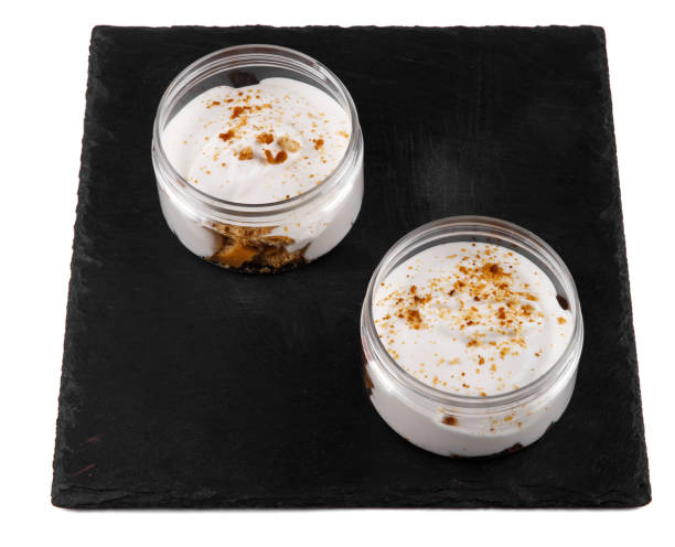 istock Honey cheesecake dessert in a jar on a black stone plate on a white background 1162579106