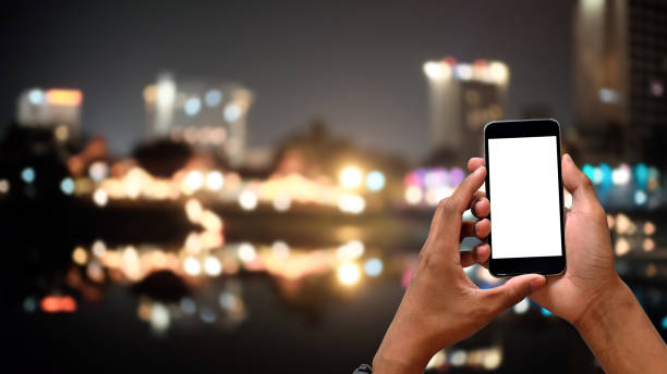 istock Man's hands using mockup smartphone with blur city night time on background. 1162583014