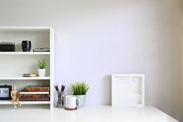 istock Workspace shelves with camera, lens with photo frame and coffee mug on table. 1162583039