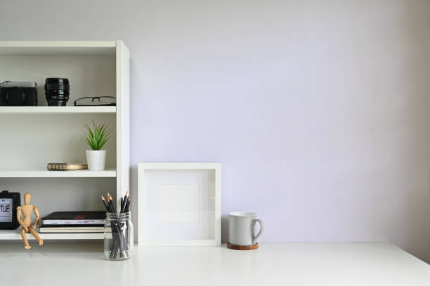 istock Workspace shelves with camera, lens with photo frame and coffee mug on table. 1162583108