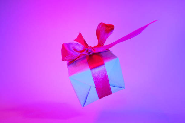 istock Gift box with red ribbon on trendy neon color background. zero gravity. levitation. copyspace. Concept sales, discount price, christmas presents and shopping 1162587800