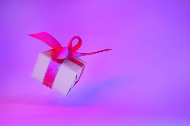 istock Gift box with red ribbon on trendy neon color. zero gravity. levitation. copyspace. Concept sales, discount price, christmas presents and shopping 1162587928