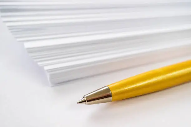 Photo of ball point pen and blank paper, tools of the writer