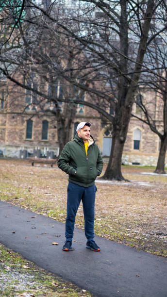 istock man with hat walking in the park 1162589112
