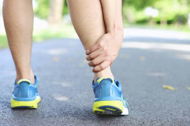 istock Runner touching painful twisted or broken ankle. Athlete runner training accident. Sport running ankle sprained sprain cause injury knee. and pain with leg bones. Focus red legs on to show pain. 1162590114