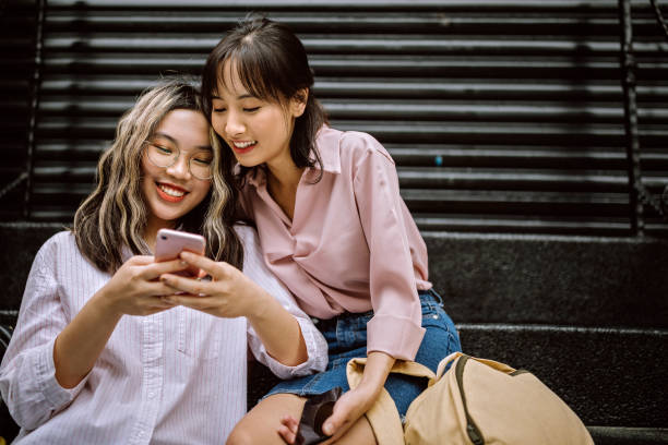 istock Modern students using smart phone in city street 1162590599