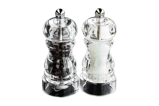 Isolated clear plastic pepper and salt grinders.