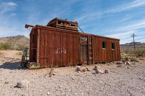 Old and abandoned railroad car in extreme terrain that was used for housing in the Rhyolite ghost town near death Valley.