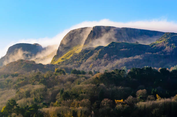Cavehill, Belfast, with low clouds and mist. Mist/low clouds roll over "Napoleon's Nose", Cave Hill, Belfast in late autumn sunshine belfast photos stock pictures, royalty-free photos & images