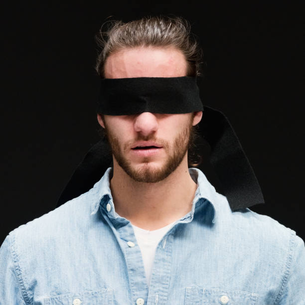 istock Headshot of handsome man with long hair blindfolded 1162604277