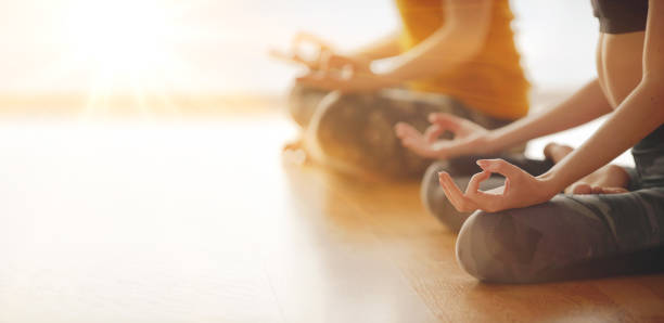 two woman doing yoga flow in studio - om symbol fotos imagens e fotografias de stock