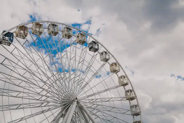 Photo of Ferris wheel on background of cloudy sky