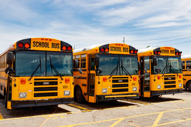 autobús escolar amarillo en un lote del distrito esperando para partir para estudiantes v - depart fotografías e imágenes de stock