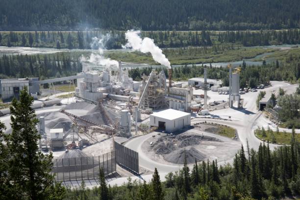 Overview of cement plant in valley and forest The plant looks very contained and effecient cement factory stock pictures, royalty-free photos & images