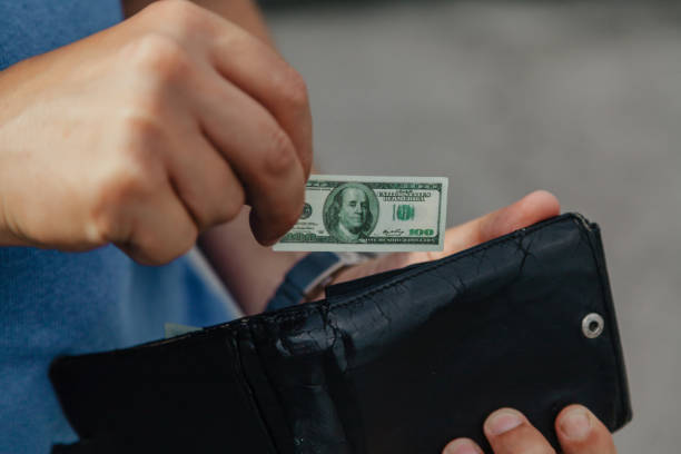 istock Hand puts toy banknote into wallet 1162607171