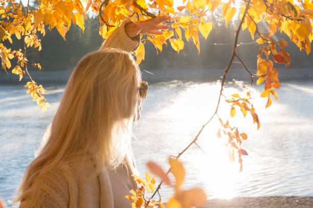 istock Woman explores lake shore in autumn 1162607221