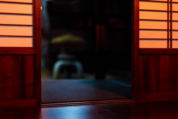 庭に石灯籠を持つ障子スライド紙のドアの暗い夜の背景に伝統的な日本の家や旅館レストラン - 旅館 ストックフォトと画像