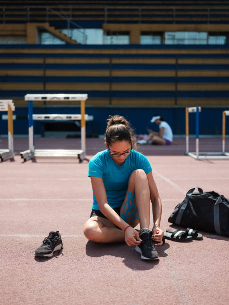 istock Athletic university student tying her running shoes 1162609769