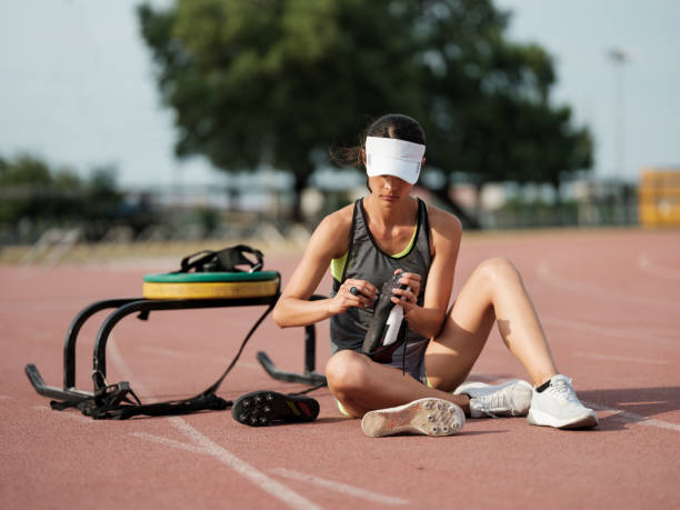 Athletic woman changing shoes before pulling a weighted sled