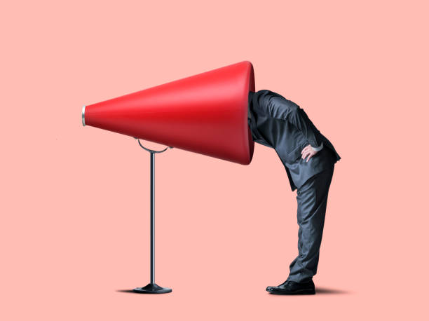istock Businessman Sticks Head Into Large Red Megaphone 1162611841