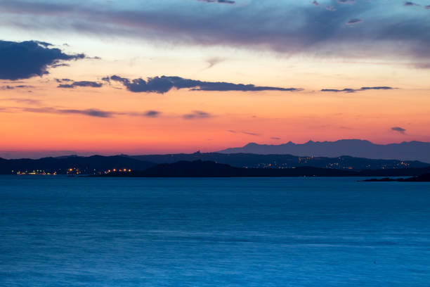 Coloré après sunset View: Océan Méditerranéen et les îles de La Maddalena et Caprera avec le ciel rouge vif et les lumières lointaines. Baia Sardaigne, Costa Smerelda, Sardaigne, Italie. - Photo