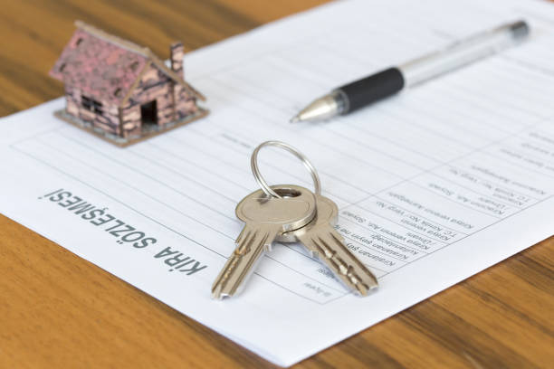 istock Turkish lease agreement form with model house, pen and keys on it. 1162613623