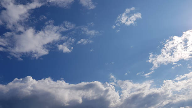 istock Clear blue sky and white fluffy clouds. Summer sunny day weather. Beautiful cloudscape with light white clouds surrounded empty space of clear blue sky in the center. High sky view. 1162614481
