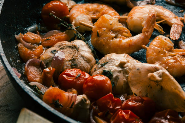 istock Frying pan with garlic cloves tomatoes and prawns 1162615676