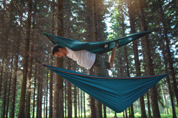 istock Bored man playing and exercising balance with hammocks 1162618195