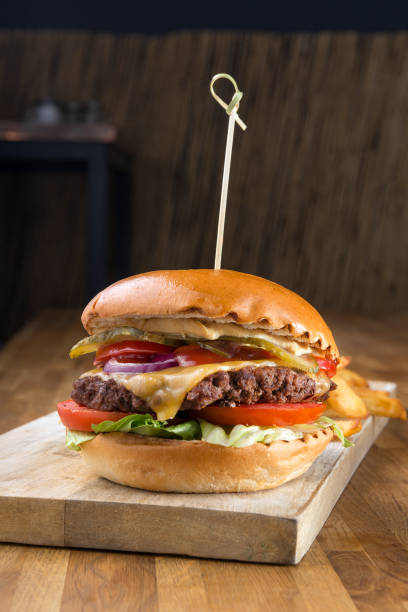 istock Burger on wooden background 1162619520