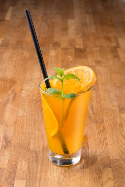istock Orange drink on wooden background 1162619527