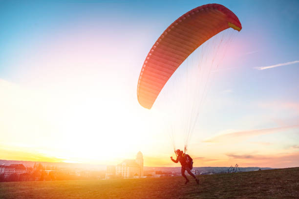 istock Paraglider getoff ground with wind against sunset 1162620437
