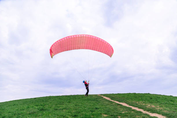 istock Man landed and tries to drop parachute on ground 1162620452