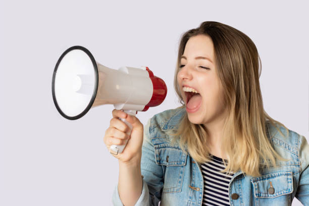 istock Young woman screaming on a megaphone. 1162621595