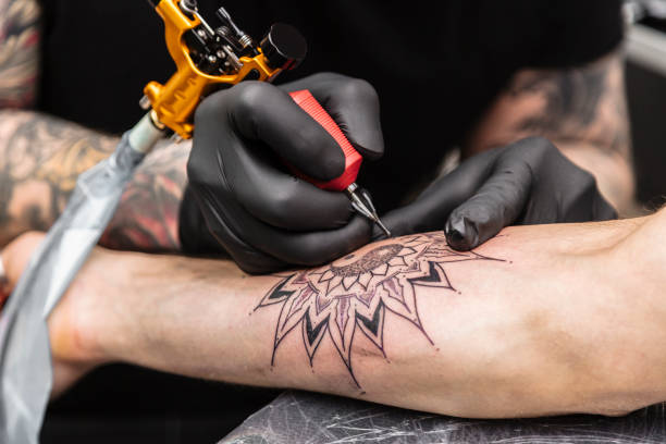 processo di creazione di tatuaggi sotto forma di fiore nero - tatuare foto e immagini stock