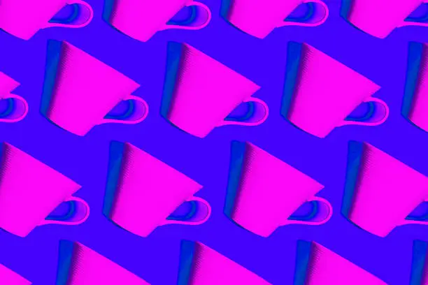Photo of Coffee pattern of neon pink cup for coffee on bright blue background.