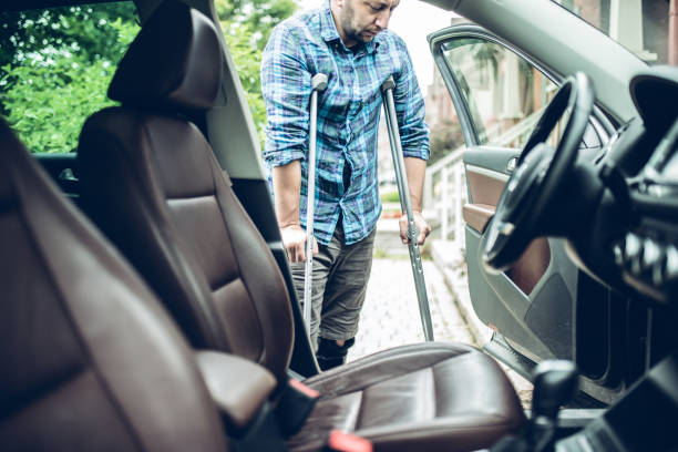 man using crutches is about to take the car man using crutches is about to take the car. view from inside the car standing had to knee pose stock pictures, royalty-free photos & images